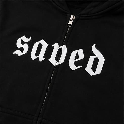 Close-up of the blackletter saved chest graphic, split by the zip